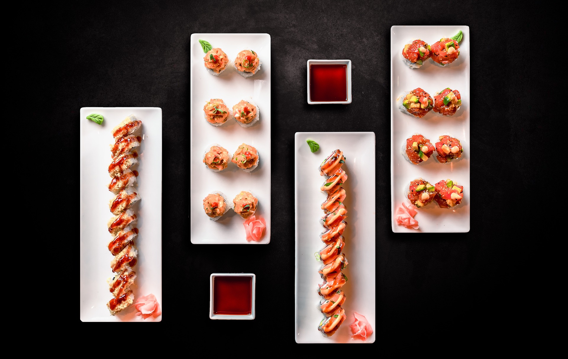 Decoratively-plated sushi on a black tabletop
